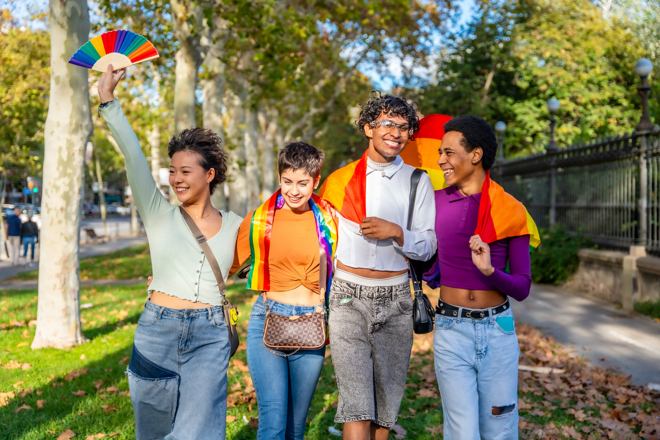 Multiethnic diversity LGBT group with rainbow flag. Multiracial friends having fun in the city at the pride march. Homosexual, lesbian, bisexual, non-binary concept